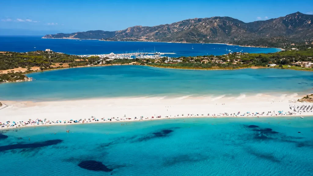 Tyrkysová laguna, bílá pláž a hory u Villasimius na Sardinii